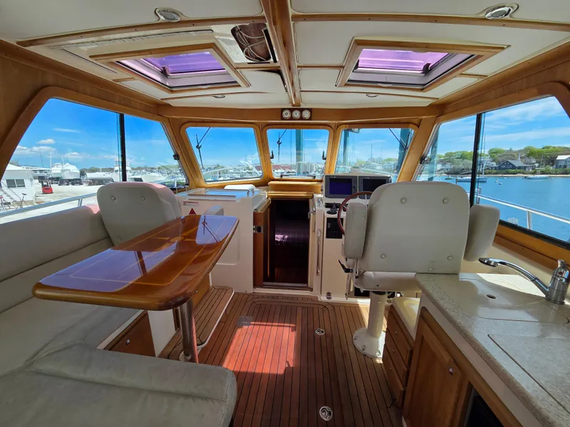 Slide: The Image of Interior of 2007 Sabre 34 Hardtop Express yacht with wood accents and panoramic windows. - 6