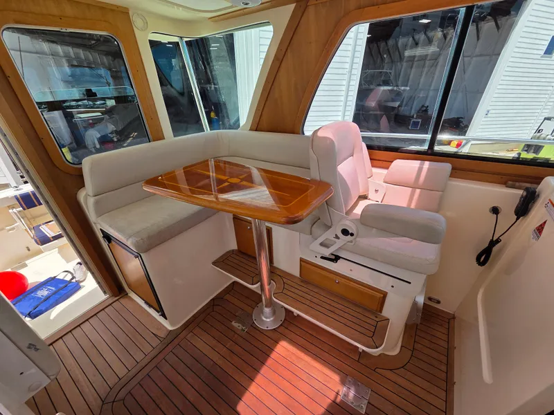 Slide: The Image of Interior of 2007 Sabre 34 Hardtop Express with seating and wooden table. - 7