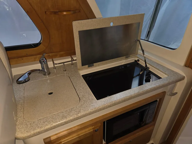 Slide: The Image of 2007 Sabre 34 Hardtop Express galley with sink, stove, and microwave. - 9
