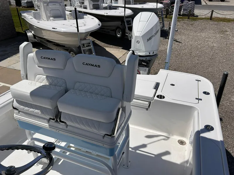 Slide: The Image of 2025 Caymas 26 HB boat interior with cushioned seating and Mercury outboard motor. - 10