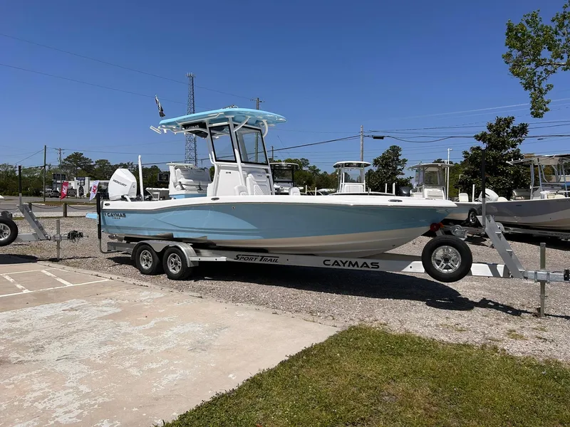 Slide: The Image of 2025 Caymas 26 HB boat on trailer, displayed outdoors under clear blue sky. - 2