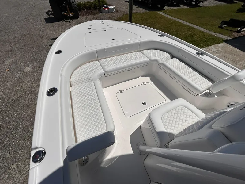 Slide: The Image of 2025 Caymas 26 HB boat with white cushioned seating and storage compartments. - 7