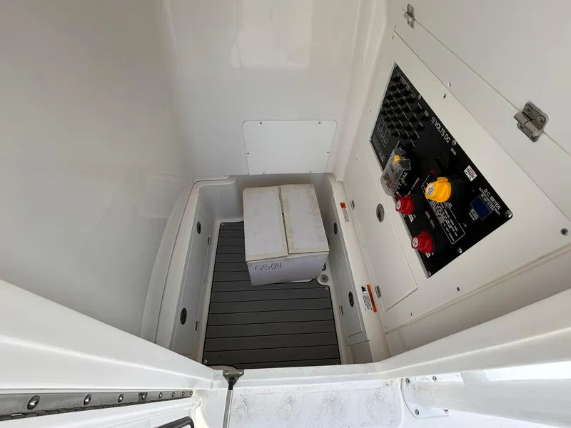 Slide: The Image of 2025 Caymas 26 HB boat interior storage compartment with control panel and battery box. - 9