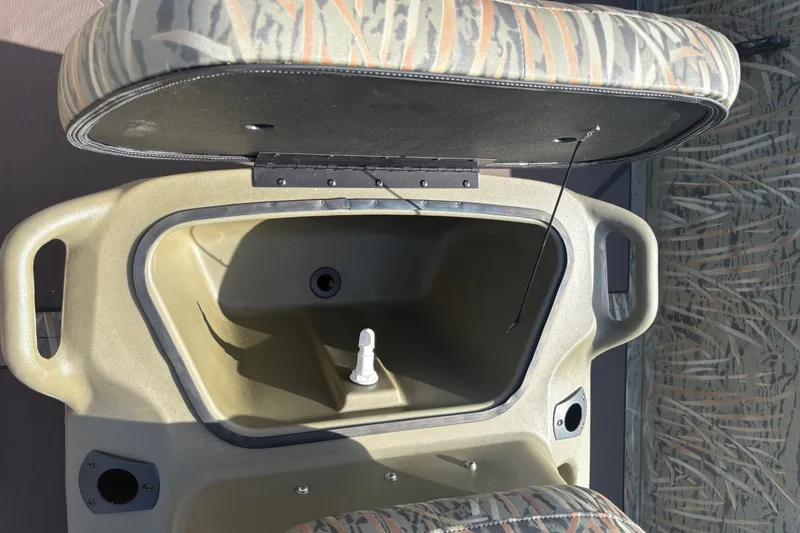 Slide: The Image of An open storage compartment with a cushioned lid in a boat, surrounded by camouflage pattern. - 15