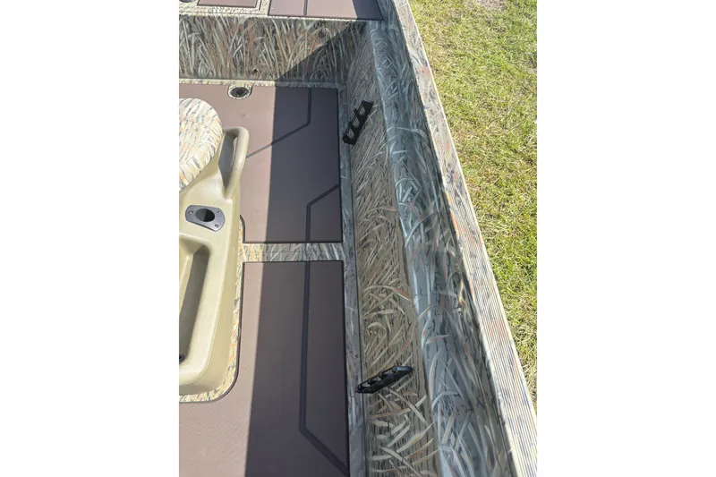 Slide: The Image of 2025 Tracker Grizzly 2072 CC boat interior with camouflage design and seating. - 13