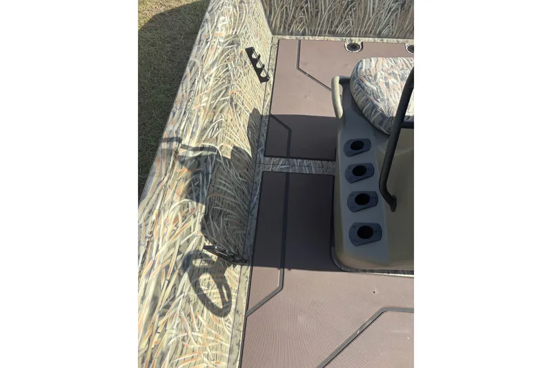 Slide: The Image of 2025 Tracker Grizzly 2072 CC boat interior with camouflage design and seating. - 14