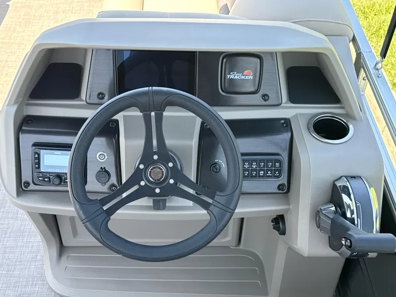 Slide: The Image of 2025 Sun Tracker Party Barge 20 DLX steering console with controls and cup holder. - 5