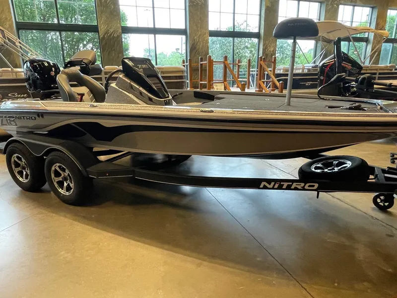 Slide: The Image of 2024 Nitro Z18 boat displayed indoors, featuring sleek design and dual-axle trailer. - 2