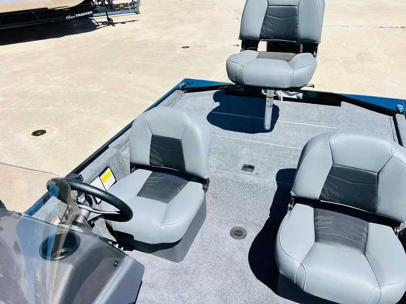 Slide: The Image of 2025 Tracker Bass Tracker Classic XL boat interior with three gray seats on a sunny day. - 15