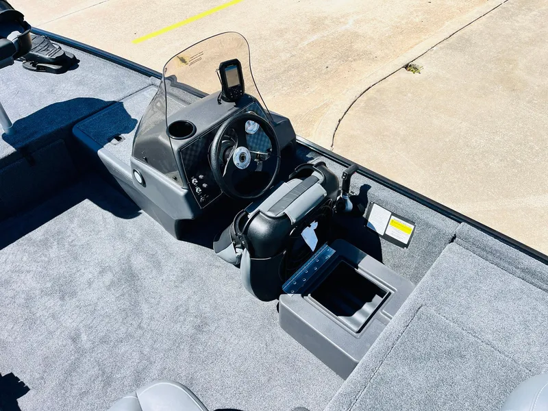 Slide: The Image of 2025 Tracker Bass Tracker Classic XL boat cockpit with steering wheel and controls. - 16