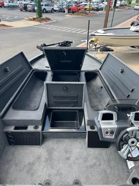 Slide: The Image of 2025 Tracker Savage 215 boat interior with storage compartments and steering console. - 4