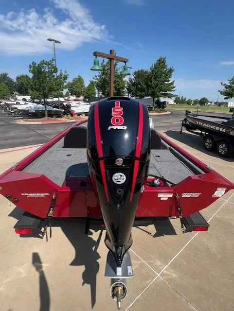 Slide: The Image of 2025 Tracker Pro Team 195 Tournament Edition boat with 150 HP engine, parked outdoors. - 2