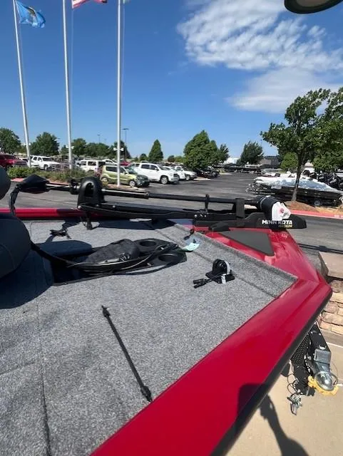 Slide: The Image of 2025 Tracker Pro Team 195 Tournament Edition boat, red exterior, parked outdoors under clear sky. - 5