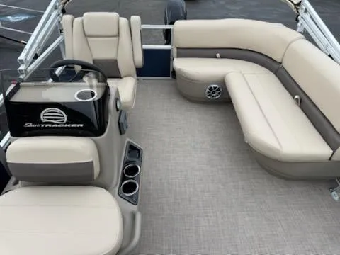 Slide: The Image of 2025 Sun Tracker Bass Buggy 16 XL Select pontoon boat interior with beige seating and steering console. - 6