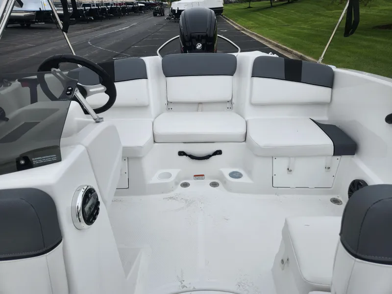 Slide: The Image of 2025 Tahoe T16 boat interior with white and gray seating, steering wheel, and storage compartments. - 4