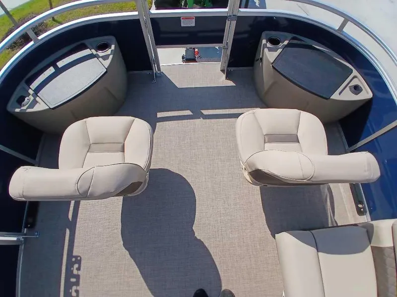 Slide: The Image of 2025 Sun Tracker Fishin' Barge 20 DLX interior with beige seating and storage compartments. - 6