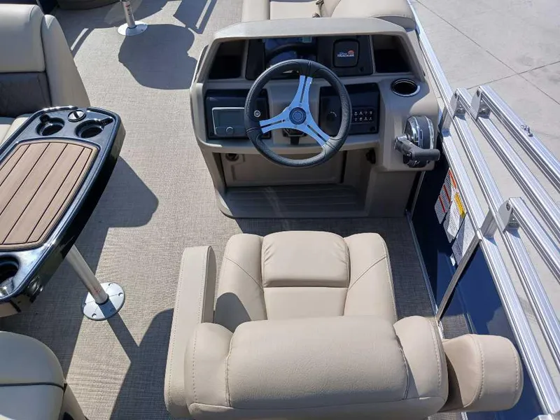 Slide: The Image of 2025 Sun Tracker Fishin' Barge 20 DLX boat interior with steering wheel and seating. - 9