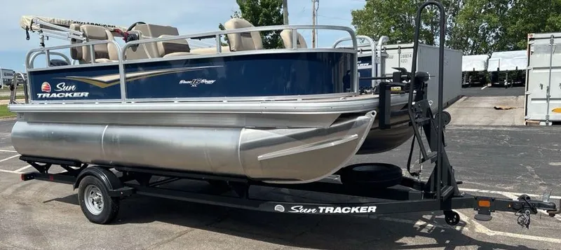 Slide: The Image of 2025 Sun Tracker Bass Buggy 16 XL Select pontoon boat on trailer. - 2