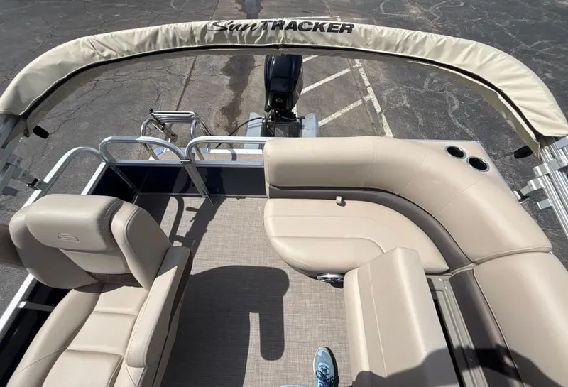 Slide: The Image of 2025 Sun Tracker Bass Buggy 16 XL Select pontoon boat interior with beige seating and canopy. - 3