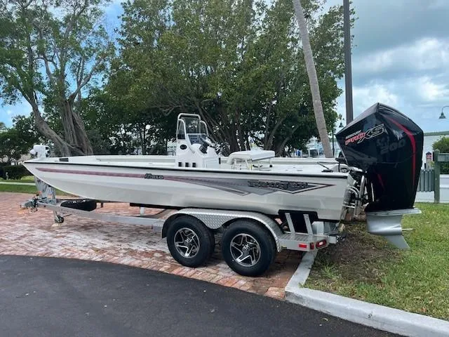 Slide: The Image of 2025 Ranger RB210 boat on trailer, parked outdoors under trees. - 2