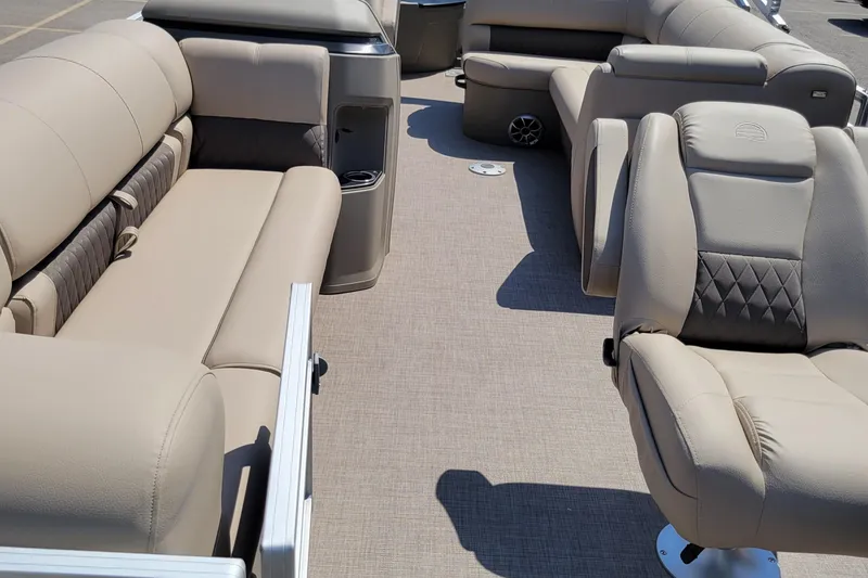 Slide: The Image of 2025 Sun Tracker SportFish 20 DLX interior with beige seating and carpeted flooring. - 2