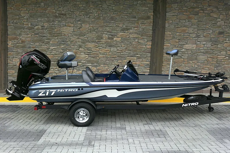 Slide: The Image of 2025 Nitro Z17 boat on trailer, parked against stone wall background. - 0