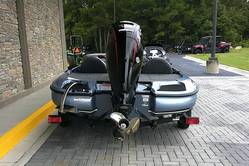 Slide: The Image of 2025 Nitro Z17 boat with powerful outboard motor, parked on a paved driveway. - 2