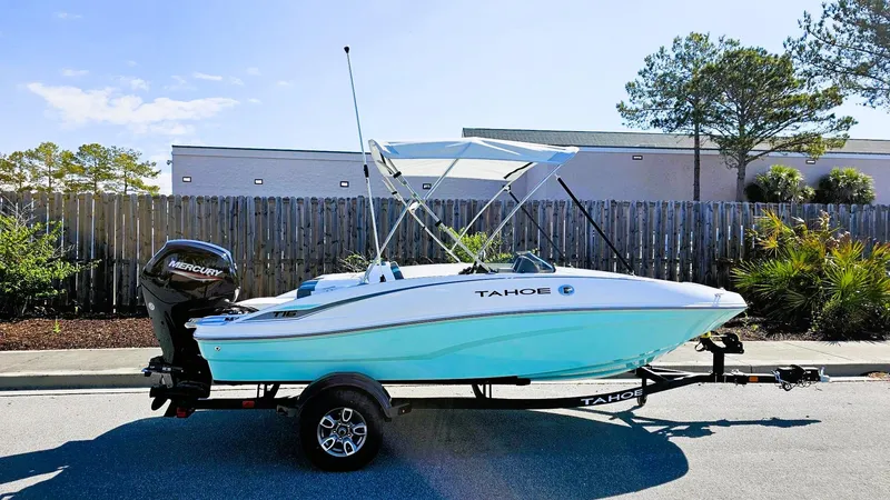 Slide: The Image of 2025 Tahoe T16 boat on trailer with outboard motor, parked outdoors. - 0