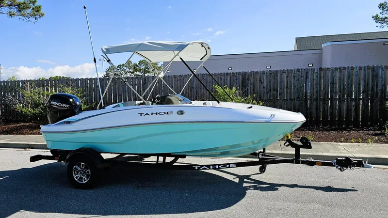 Slide: The Image of 2025 Tahoe T16 boat with canopy on trailer, parked outdoors. - 1