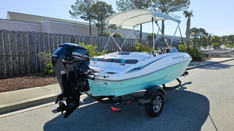 Slide: The Image of 2025 Tahoe T16 boat with Mercury engine on trailer, parked outdoors. - 2
