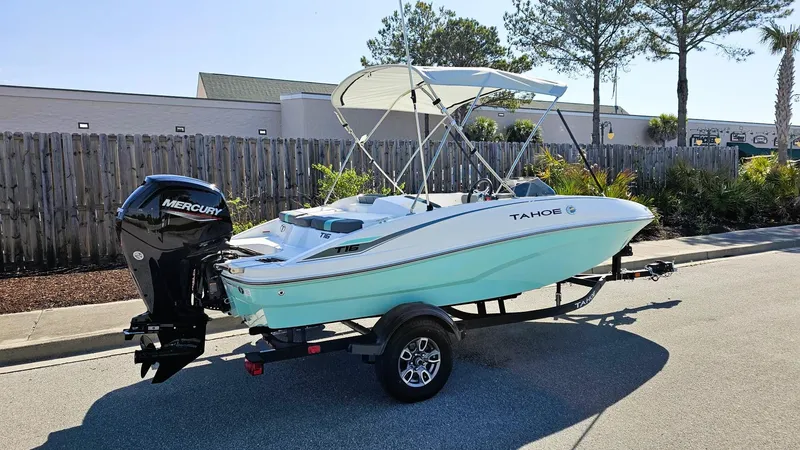 Slide: The Image of 2025 Tahoe T16 boat with Mercury engine on trailer, parked outdoors. - 3