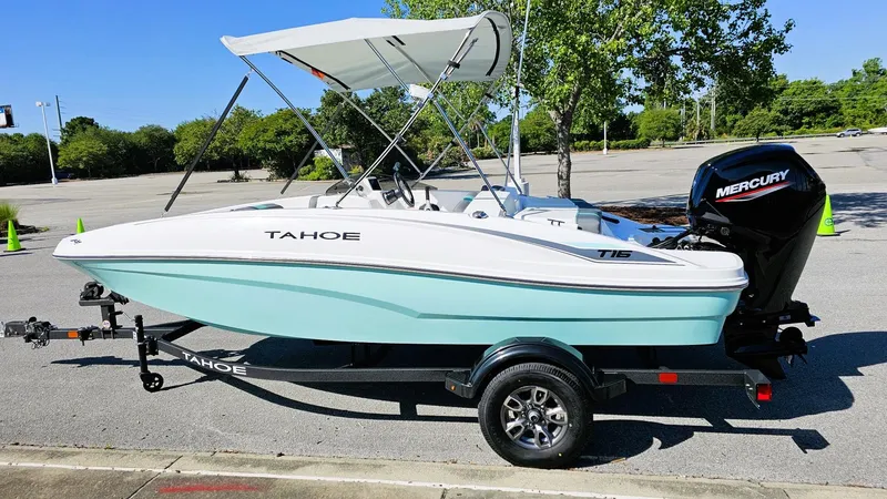 Slide: The Image of 2025 Tahoe T16 boat with canopy and Mercury engine on trailer in parking lot. - 4