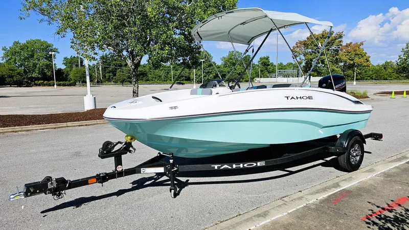 Slide: The Image of 2025 Tahoe T16 boat on trailer, parked outdoors with canopy, sunny day. - 6