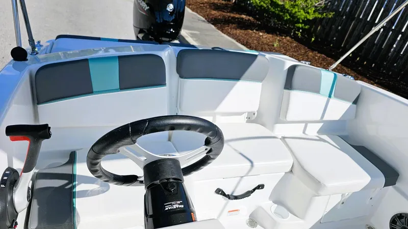 Slide: The Image of 2025 Tahoe T16 boat interior with steering wheel and cushioned seating. - 9