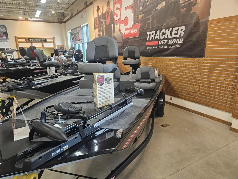 Slide: The Image of 2025 Tracker Bass Tracker Classic XL boat displayed in showroom with promotional banner. - 2