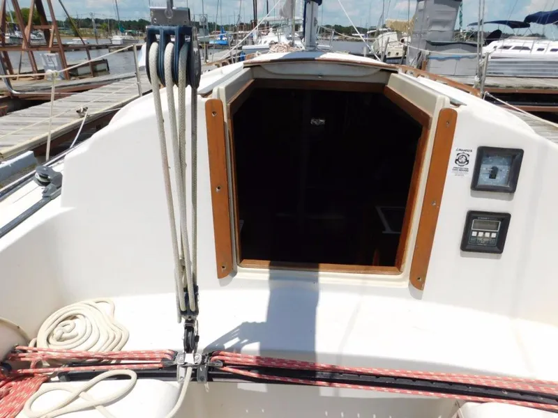 Slide: The Image of 1981 Pearson 32 sailboat cockpit with ropes and open cabin entrance at marina. - 11