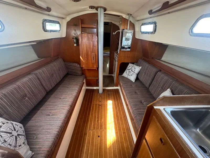 Slide: The Image of Interior of 1981 Pearson 32 sailboat with wood finish and striped cushions. - 21