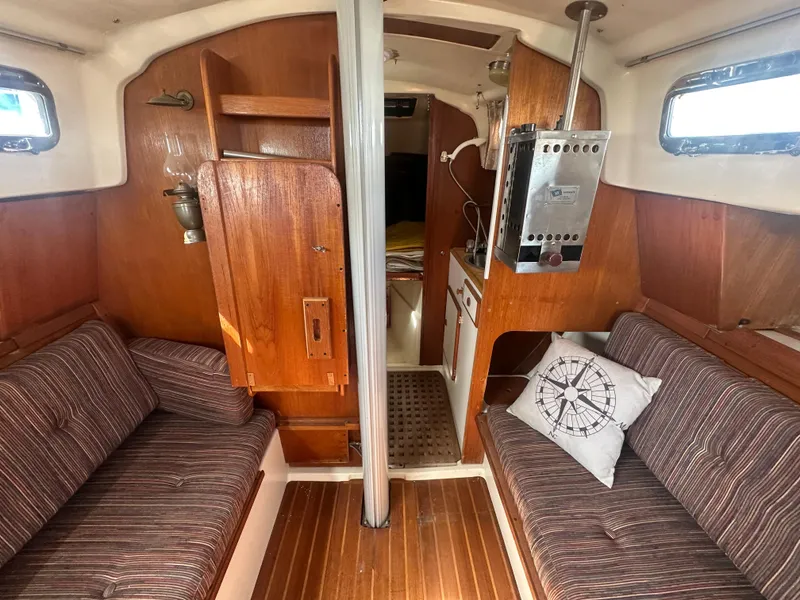 Slide: The Image of Interior of 1981 Pearson 32 sailboat with wood paneling and striped seating. - 22