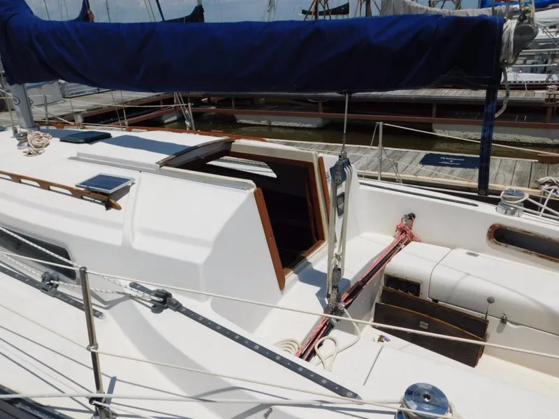 Slide: The Image of 1981 Pearson 32 sailboat with blue sail cover, docked at marina. - 3