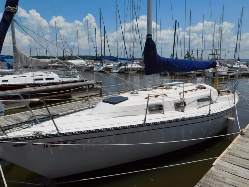 The Image of 1981 Pearson 32 sailboat docked at marina under blue sky. - 0