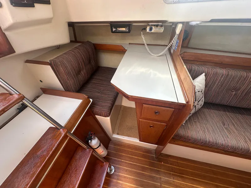 Slide: The Image of Interior of a 1981 Pearson 32 sailboat with wooden furnishings and seating area. - 16