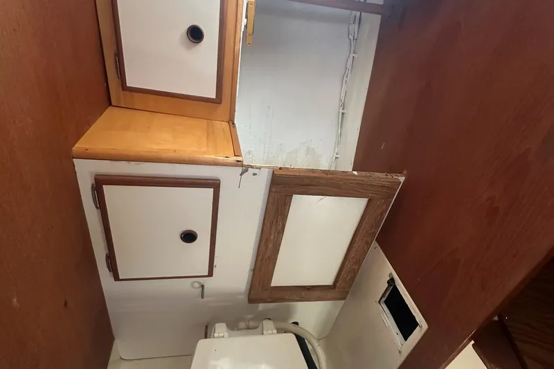 Slide: The Image of Interior of 1981 Pearson 32 sailboat showing wooden cabinets and storage area. - 25