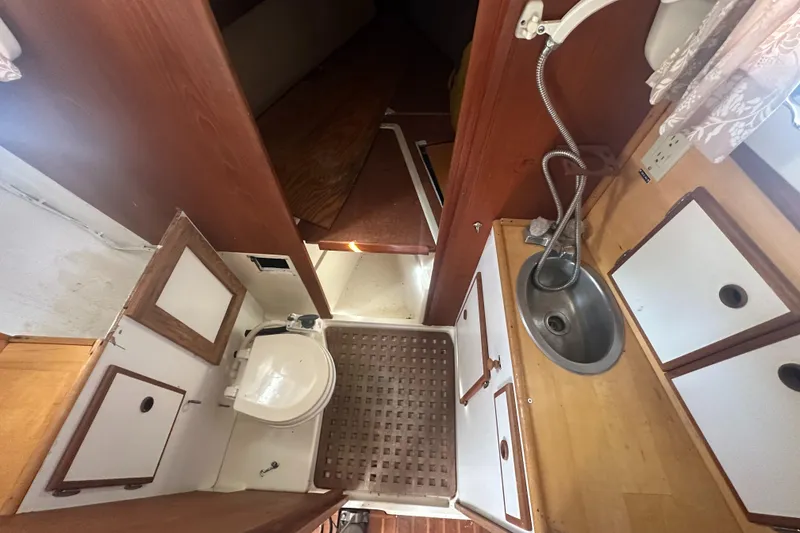 Slide: The Image of Interior of 1981 Pearson 32 sailboat bathroom with sink, toilet, and wooden cabinetry. - 27