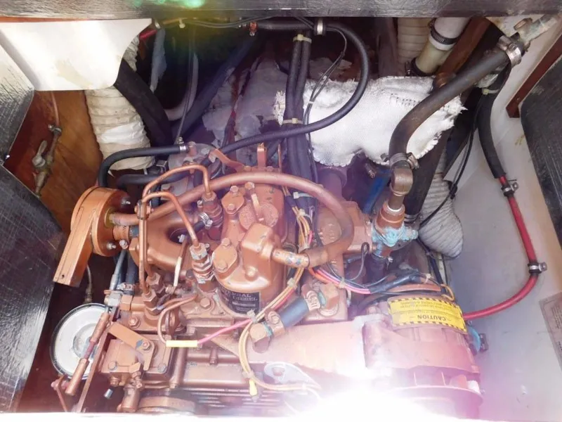 Slide: The Image of Engine compartment of a 1981 Pearson 32 sailboat, showcasing mechanical components and wiring. - 28