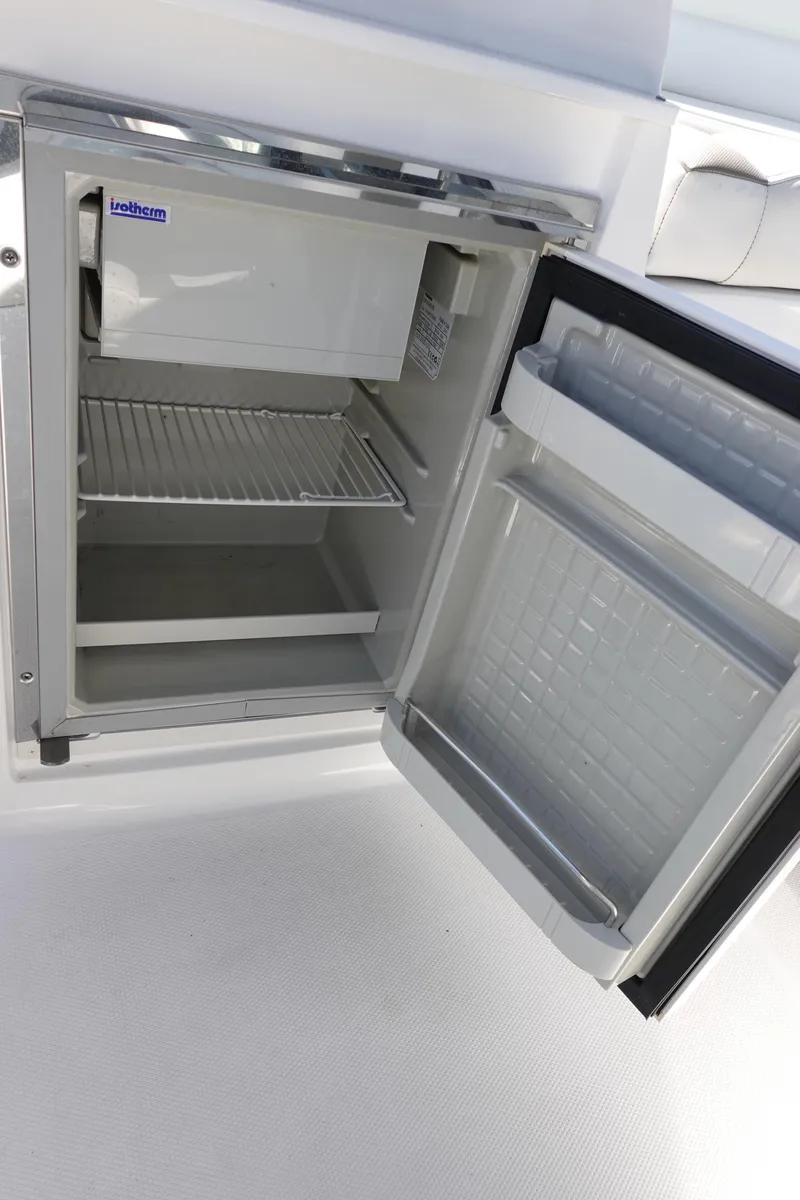 Slide: The Image of Open mini fridge on 2018 Monterey 295 Sport Yacht, showing interior shelves and freezer compartment. - 16