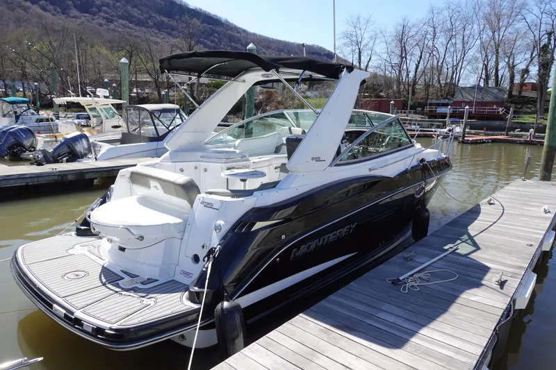 Slide: The Image of 2018 Monterey 295 Sport Yacht docked, featuring sleek design and spacious deck. - 2