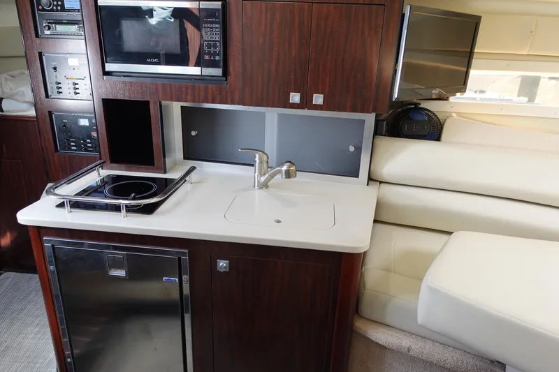 Slide: The Image of 2018 Monterey 295 Sport Yacht interior with kitchenette, microwave, and seating area. - 22