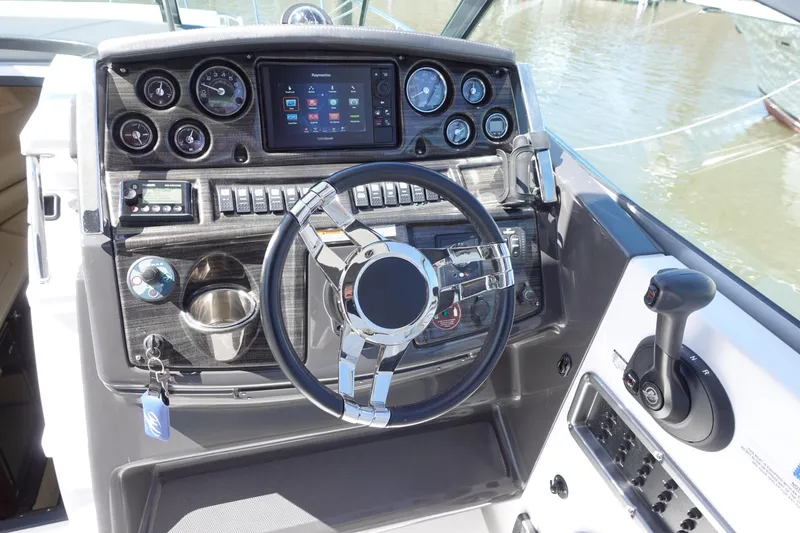 Slide: The Image of 2018 Monterey 295 Sport Yacht helm with modern controls and navigation system. - 8