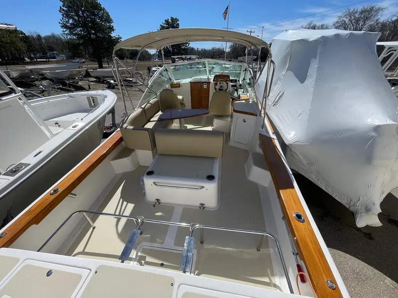 Slide: The Image of 2010 Hunt Yachts Harrier 25 boat with open deck and seating, docked outdoors. - 10