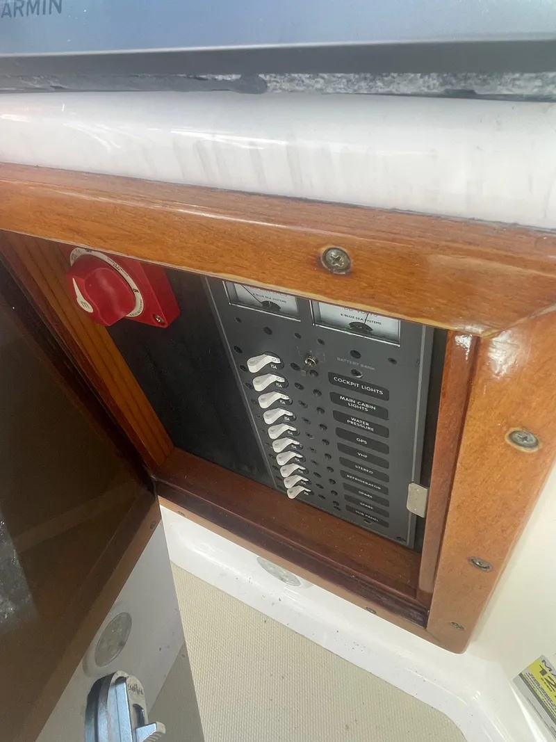 Slide: The Image of Control panel of a 2010 Hunt Yachts Harrier 25, featuring switches and wooden trim. - 17